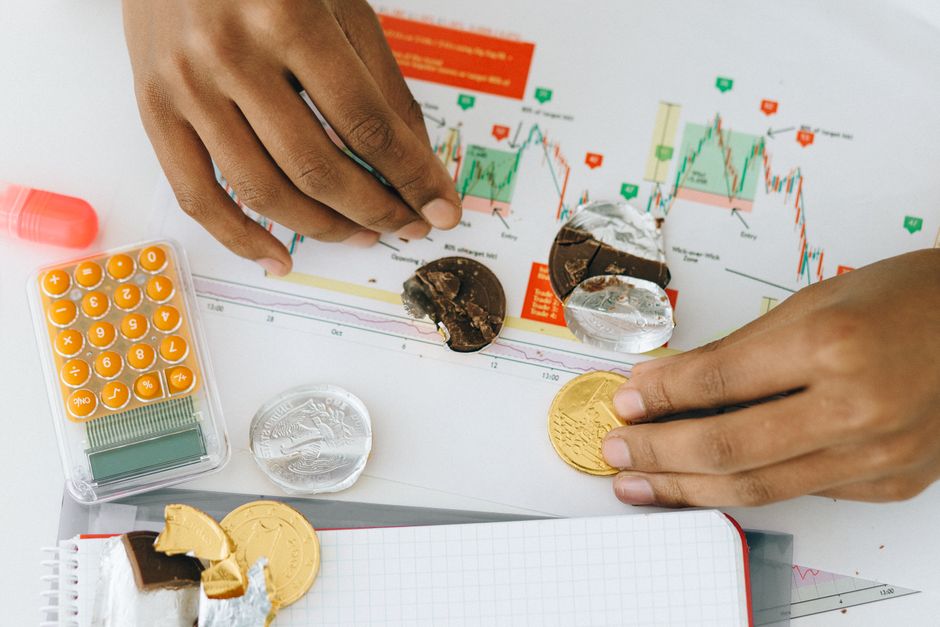 Analyzing financial charts with a calculator and chocolate coins