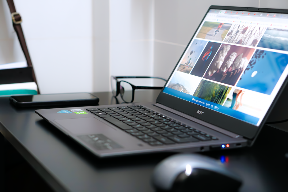 A sleek laptop on a desk with glasses and mouse