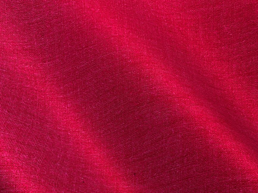 Close-up of a vibrant red linen fabric showing textures and natural folds