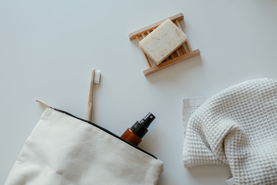 A flat lay of eco-friendly bathroom essentials including soap, towel, and spray bottle