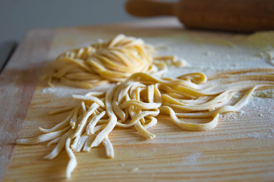Close-up of fresh uncooked pasta on a flour-dusted wooden board