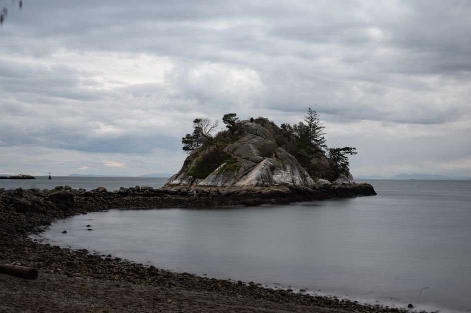 Tranquil view of Whytecliff Park's shoreline island with cloudy skies in West Vancouver, BC
