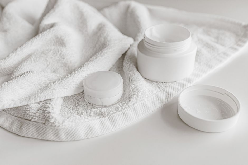Clean and minimalist presentation of skincare products with a towel